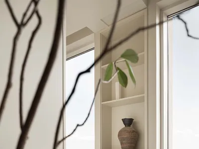 Modern ceramic vase sitting on a white console table in a living room.