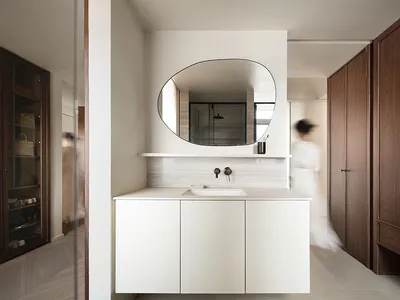 Modern minimalist bathroom with white cabinets, marble countertop, and wooden cabinets.