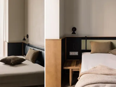 A minimalist bedroom featuring a wooden bed frame with leather and textile bedding, minimalistic decor, and natural lighting