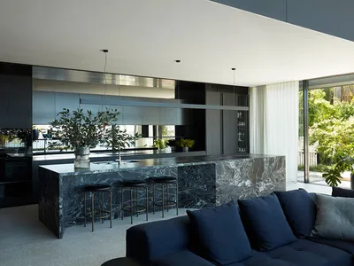 A contemporary kitchen featuring a marble countertop and black cabinetry.