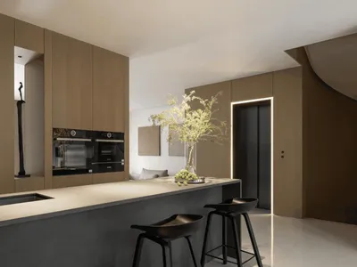 A minimalistic kitchen with concrete flooring and wooden cabinets, featuring a bar area with black stools and a vase of flowe