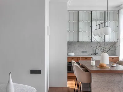 A modern kitchen with minimalist design, wooden finishes, and a stone island.