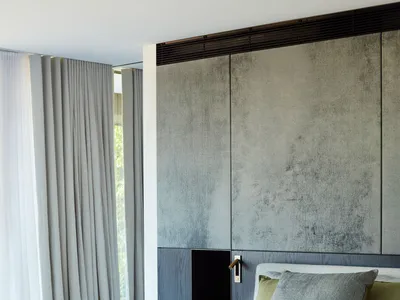 A minimalist bedroom featuring fabric bedding, a wooden bed frame, and a metal side table.
