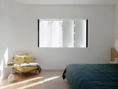 A minimalist bedroom featuring wood, fabric, and metal materials.