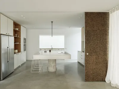 Minimalist kitchen with concrete floor and white cabinetry