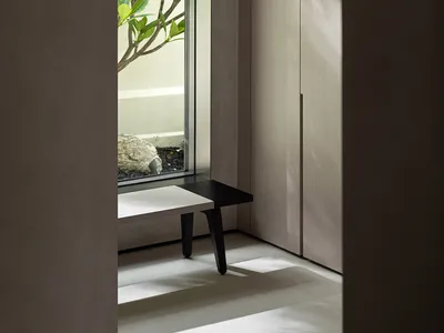 一間極簡臥室，設有玻璃櫃，採用極簡設計與現代美學。
