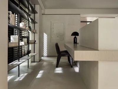 A minimalist home office featuring a concrete cabinet and a sleek, contemporary workspace.