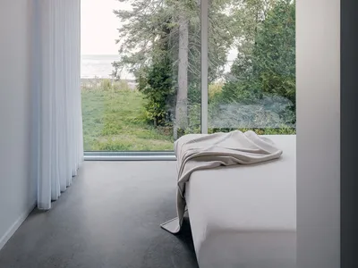 Bedroom with minimalist design, large window, and natural view.
