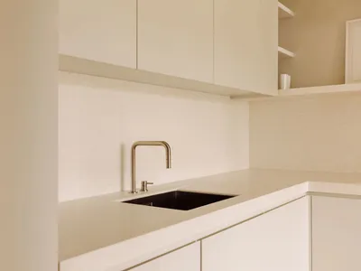 A modern kitchen featuring a sleek stone countertop and minimalist design.
