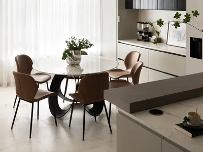Modern kitchen with marble table, leather chairs, and floating glass cabinets.