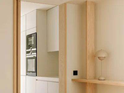 Modern, minimalist kitchen with white cabinetry and sleek appliances.