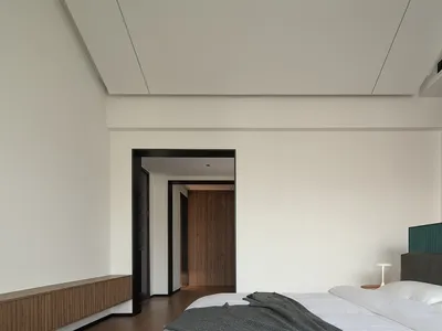 一間現代簡約臥室，擁有白牆、簡約床頭板，以及木質地板。