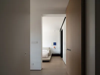 A modern minimalist bedroom featuring neutral tones and a sleek design.
