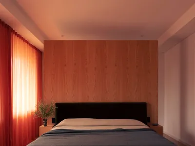 A minimalist bedroom with a wooden wall and a bed covered with blue textiles.