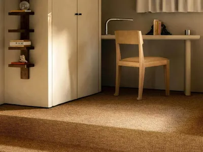 Minimalist home office with a neutral color scheme, featuring a desk, chair, and bookshelf.