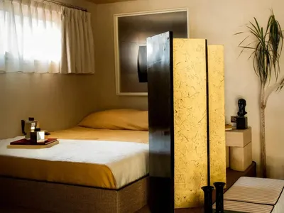 A minimalist bedroom featuring wooden panels, fabric bedding, and metal accents.