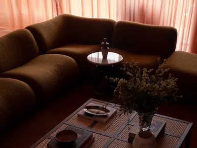 Modern industrial living room with brown couch, coffee table, and floral arrangement.