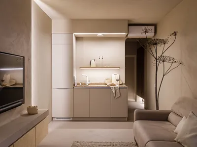 A minimalist residential kitchen with concrete walls and neutral color cabinets.