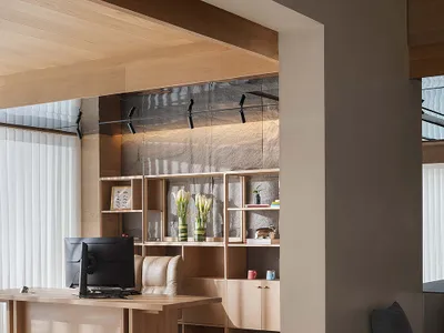 A modern home office with wooden furniture and shelving.