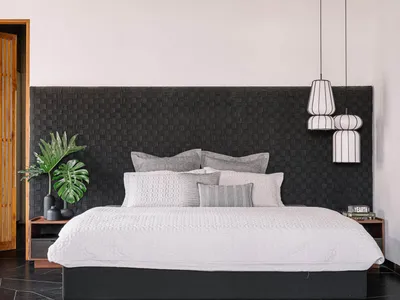 A modern bedroom with a concrete ceiling, glass fronted nightstands, and a floating bed.