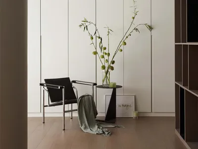 A minimalist bedroom with led lighting, wooden floors, and a black chair.