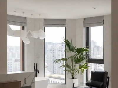 A minimalist bedroom featuring marble walls and a large window with a city view.