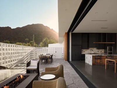 Contemporary residential kitchen with concrete and glass materials and marble countertops.
