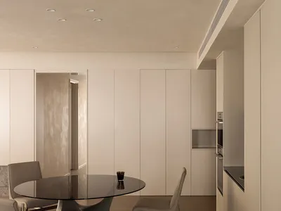 Modern minimalist kitchen interior with a focus on concrete textures and smooth lines.