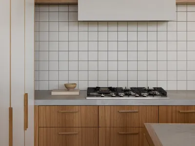 現代廚房搭配白色瓷磚 backsplash、木質櫥櫃與混凝土檯面。