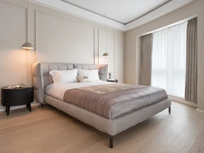 A minimalist bedroom with a modern bed and elegant fabric decor.