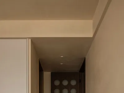 A minimalist bedroom doorway with wooden panels and circular cutouts.
