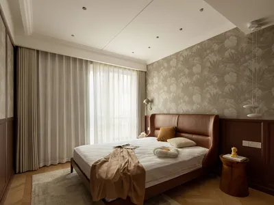 A modern bedroom featuring a leather bed, fabric bedding, and a wallpaper accent wall.