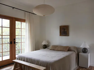 A minimalist bedroom with a bed made of cotton and linen blend sheets.
