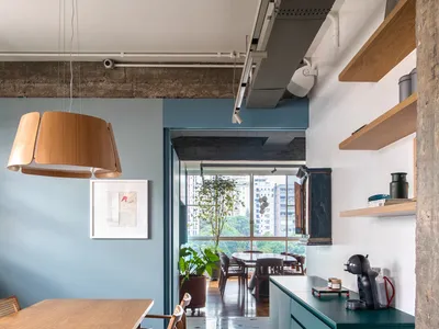 Modern kitchen with wood dining table, concrete backsplash, and terrazzo floor