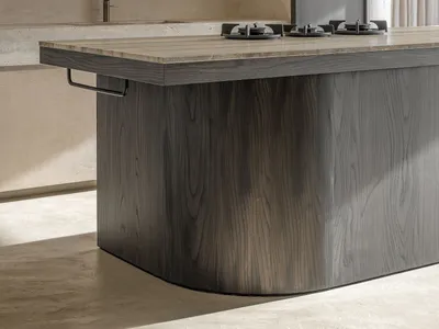 Modern kitchen with wooden island, sink, and stove.