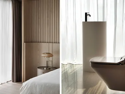 A minimalist bedroom with a wooden panel wall and a modern lamp on a side table.
