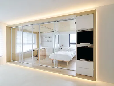 A modern minimalist bedroom featuring a glass partition wall for a unique design.