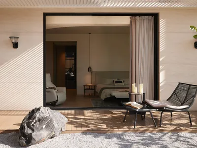 A minimalist bedroom with a wooden floor, bed, and side table.