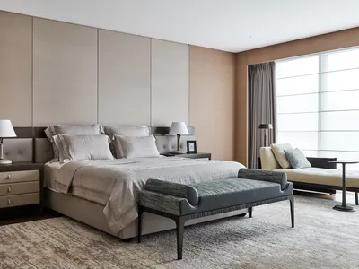 Modern minimalist bedroom with fabric bedding, wooden headboard, and metallic accents.
