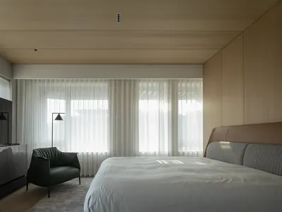 現代臥室搭配白色窗簾、木質牆面與大型窗戶