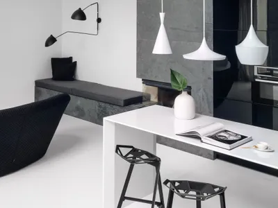 Modern minimalist kitchen with concrete materials and white pendant lights.