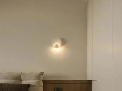 A modern minimalist bedroom with a single bed adorned with a beige textured headboard and matching cover, accompanied by a fl
