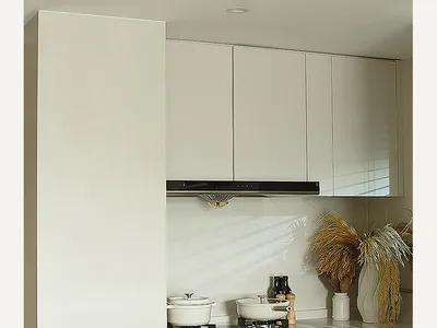 A modern, minimalist kitchen featuring marble countertops and sleek, white cabinetry.