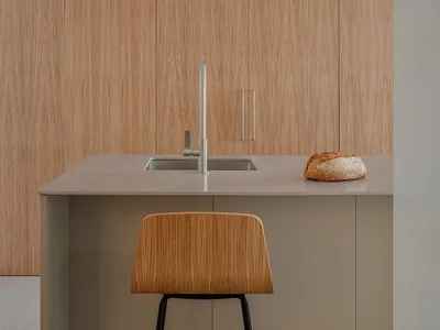 Modern minimalist kitchen with concrete countertops and a bread loaf on the countertop.