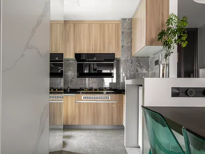 Modern kitchen interior with wooden cabinets and marble countertops.
