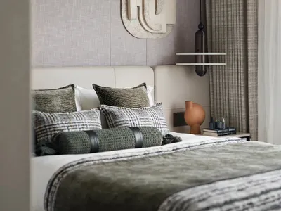 Modern bedroom featuring a bed with textured cushions and a textured wall panel.