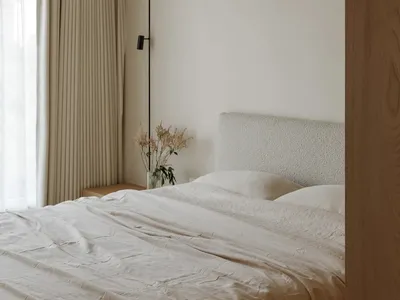 Modern bedroom with neutral colors, minimalist design, and a queen-sized bed.