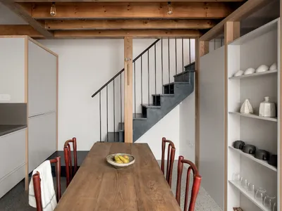 A modern kitchen with wooden elements and white cabinets.