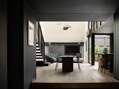 Modern kitchen featuring marble and wood elements with a living area