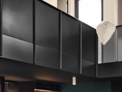 A modern kitchen featuring a marble counter and a copper pillar.